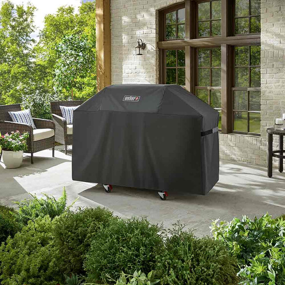 Housse de protection Weber Premium Genesis 300 sur barbecue installé sur une terrasse