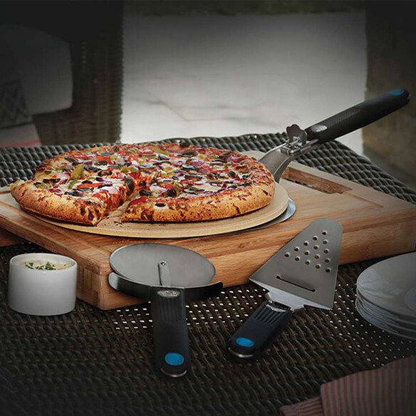 Mise en situation des accessoires à pizza Napoleon avec pizza posée sur la pierre et la pelle