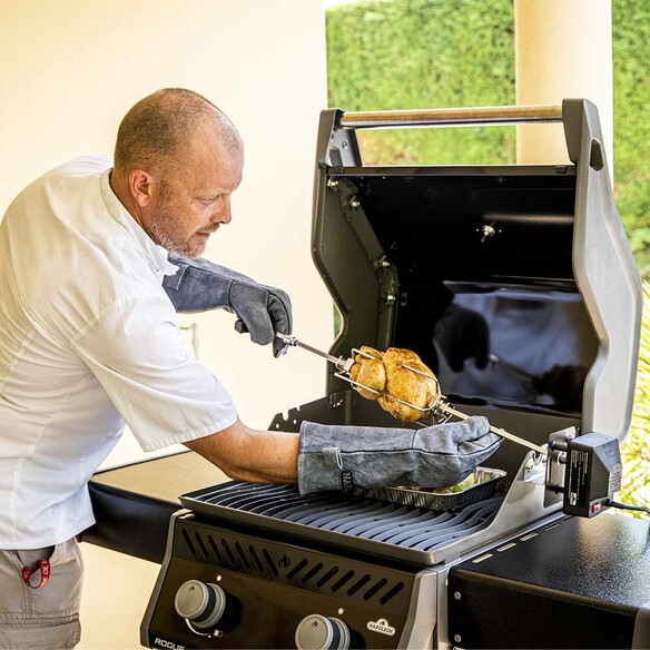 Pose d'une rôtissoire sur barbecue avec port de gants de protection Napoleon