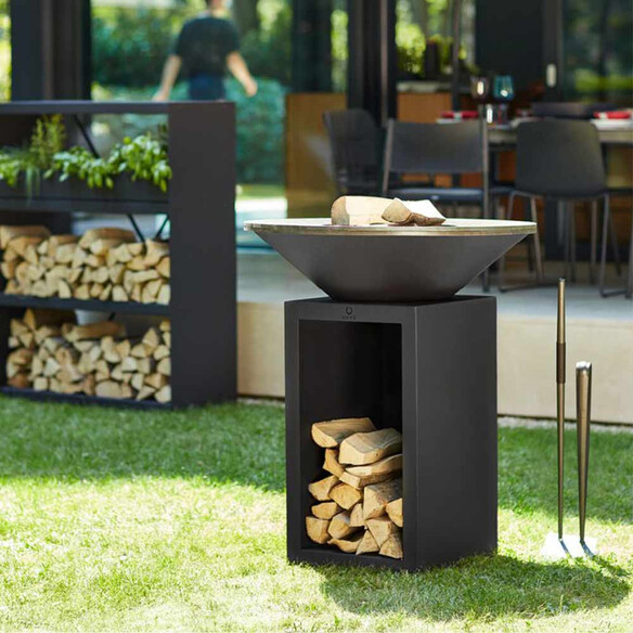 Brasero corten noir OFYR Classic Storage 85 installé sur une pelouse