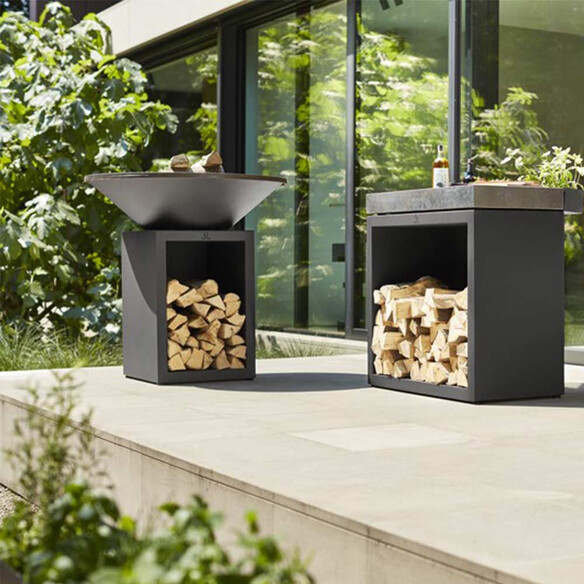 Brasero corten noir OFYR Classic Storage 85 posé sur une terrasse en pierre