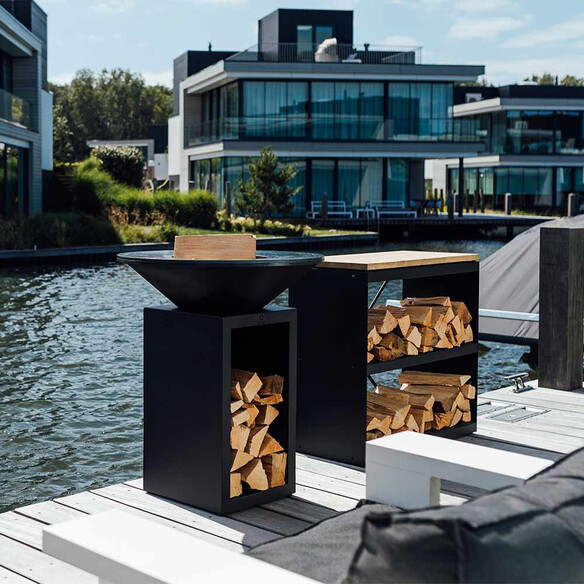 Brasero corten noir OFYR Classic Storage 85 installé au bord de l'eau