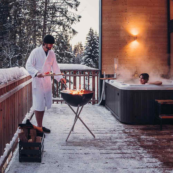 Installation du Brasero Hofats Bowl barbecue haut près d'un jacuzzi sous la neige