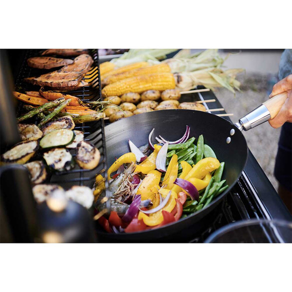 Saisie de légumes dans le wok installé sur la grille Culinary Modular du Barbecue gaz Select 3 LX Plus Campingaz