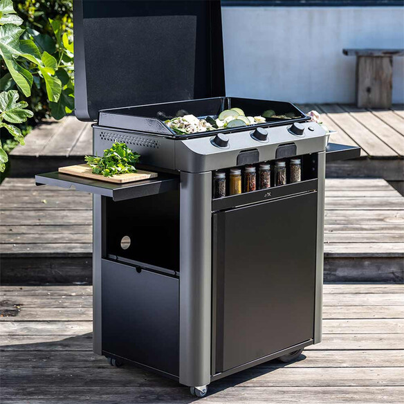 Cuisson sur la plancha Fusion 75 gris cargo posé sur sa desserte avec tablettes dépliées sur une terrasse