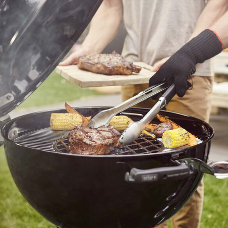 Cuisson de viandes sur la grille de saisie en fonte Weber dans un barbecue charbon Master-Touch Weber