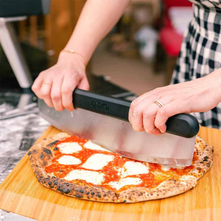 Découpe d'une pizza sur la pelle à pizza bambou 40 cm Ooni