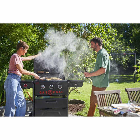 Un couple qui cuisine sur le barbecue hybride Gas2Coal 2.0 Special Edition 4 brûleurs Char-Broil