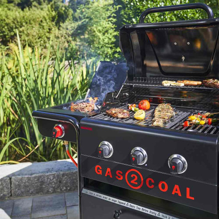 Vue sur le barbecue hybride Gas2Coal 2.0 Special Edition 4 brûleurs Char-Broil ouvert en pleine cuisson