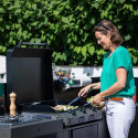 Femme qui cuisine sur une plancha Fusion 75 posée sur un modulo ENO en acier gris