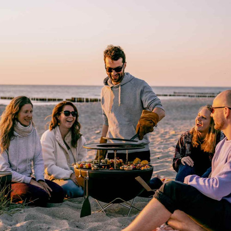 Personne qui lève la grille de saisie du brasero Bowl 57 Hofats