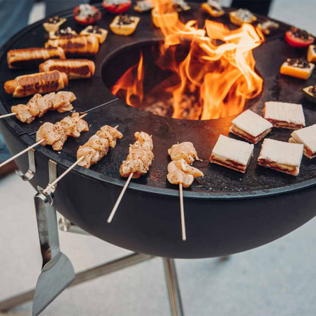 Cuisson d'aliments sur la demi-plancha en fonte émaillée du brasero Bowl 70 Höfats