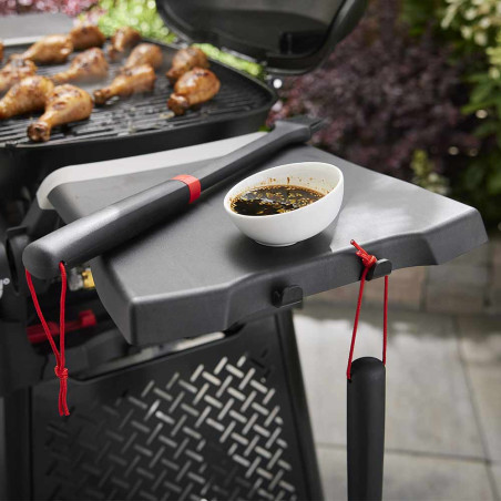 Image lifestyle avec tablette latérale sur barbecue gaz Serie Q 2000 N Weber