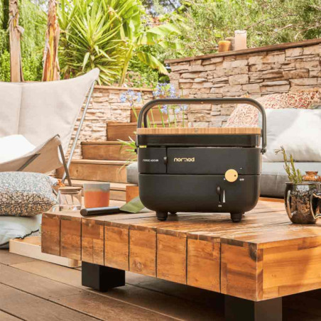 Plancha gaz NOMAD Forge Adour sur une table en bois dans un extérieur Plancha gaz NOMAD Forge Adour sur une table en bois dans un extérieur