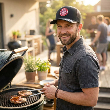 Homme cuisinant sur un kamado et portant la casquette trucker Esprit Barbecue