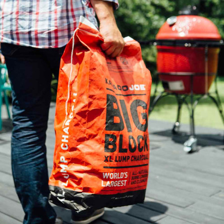 Homme portant le sac de charbon de bois 9 kg Kamado Joe