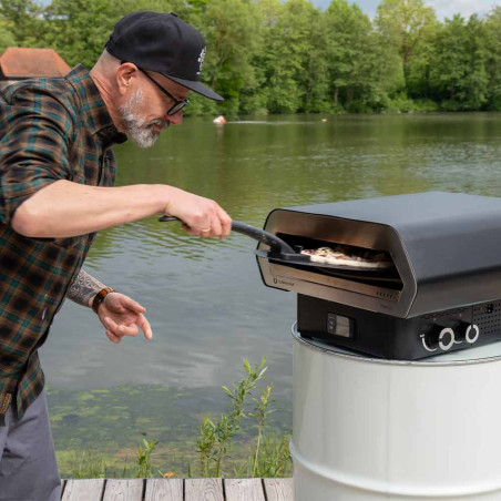 Pelle à pizza noire Prismo Outdoorchef - cuisson d'une pizza