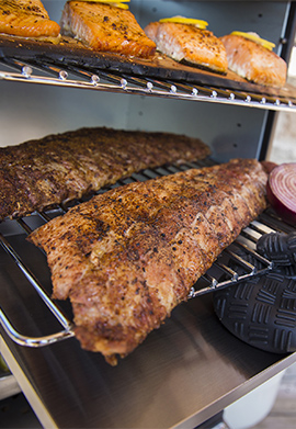 Ribs fumés et pavés de saumon fumés dans un fumoir vertical à chaud