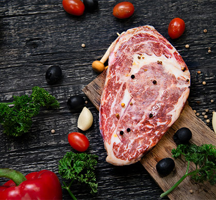 Viande crue sur une plancha en bois