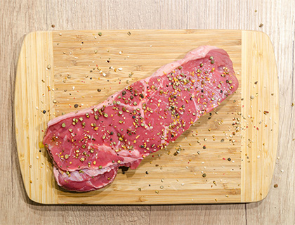 Viande crue sur une plancha à découper