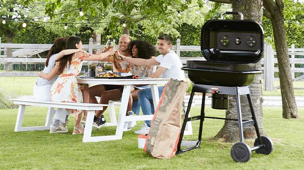 Barbecue charbon Magnus Compact à 2 roues et 2 pieds dans un jardin