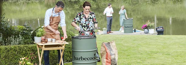 Barbecue charbon Edson Army Green dans un grand jardin avec des personnes préparant un repas dessus