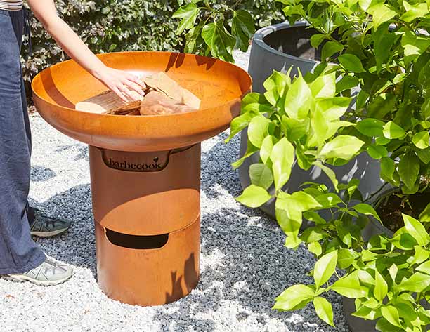 Ajout de bois dans le brasero plancha Jack 75 Barbecook