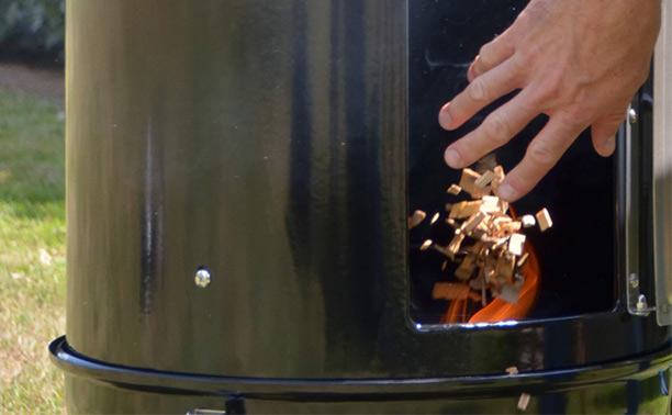 Insertion de copeaux de bois de Hêtre Esprit Barbecue dans un fumoir