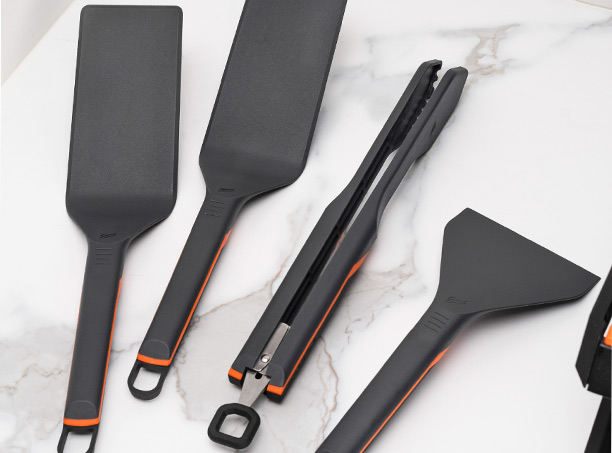 4 accessoires Blackstone pour plancha électrique Série E posés sur un plan de travail