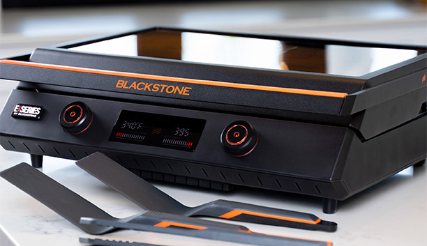 Plancha électrique Série E-56 avec couvercle de cuisson Blackstone posé sur un plan de travail de cuisine