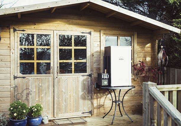 Fumoir à chaud électrique numérique Bradley Smoker 4 étages près d'un cabanon en bois