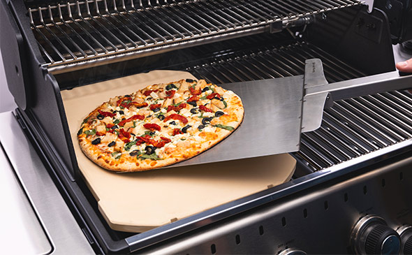 Pizza cuite sur la pierre à pizza installée dans un barbecue Broil King