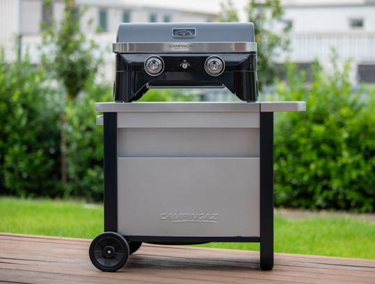 Barbecue Attitude LX posé sur la desserte Deluxe Campingaz