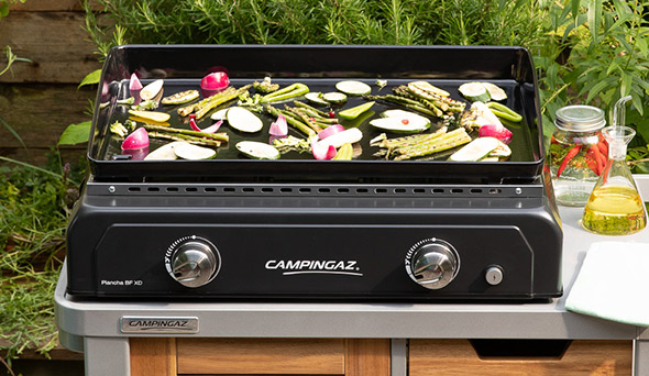 Cuisson de légumes sur la plaque en fonte émaillée de la plancha Blue Flame XD Campingaz