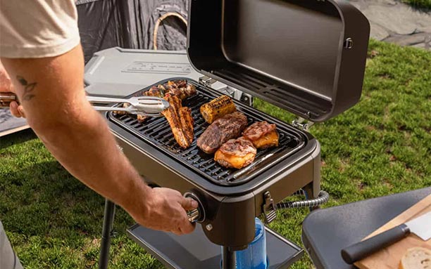 Cuisson d'aliments sur la grille en acier émaillé du barbecueTour & Grill Campingaz