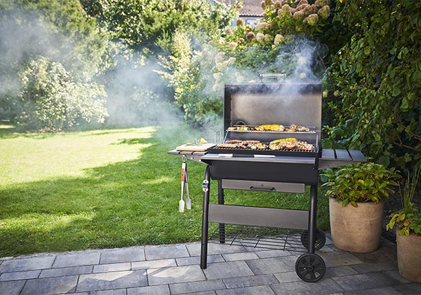 Barbecue charbon Charcoal Large Char-Broil allumé sur une terrasse