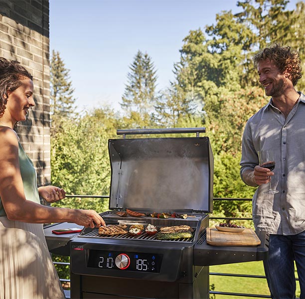 Barbecue électrique Evolve Char-Broil sur une terrasse avec le couvercle ouvert