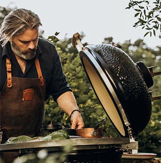 Chef cuisinier cuisinant sur barbecue kamado