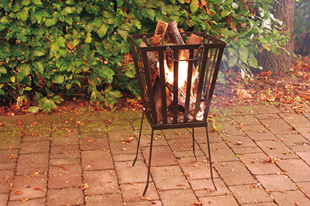 Brasero panier avec bois en combustion sur un sol en briques