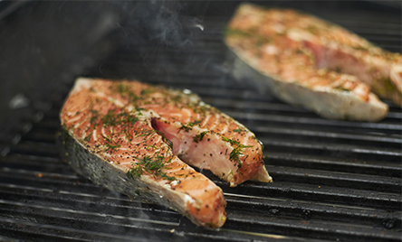Cuisson indirecte de pavés de saumon posés sur une grille de barbecue