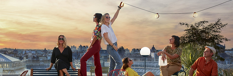 Soirée sur un rooftop parisien avec les lampes Fermob