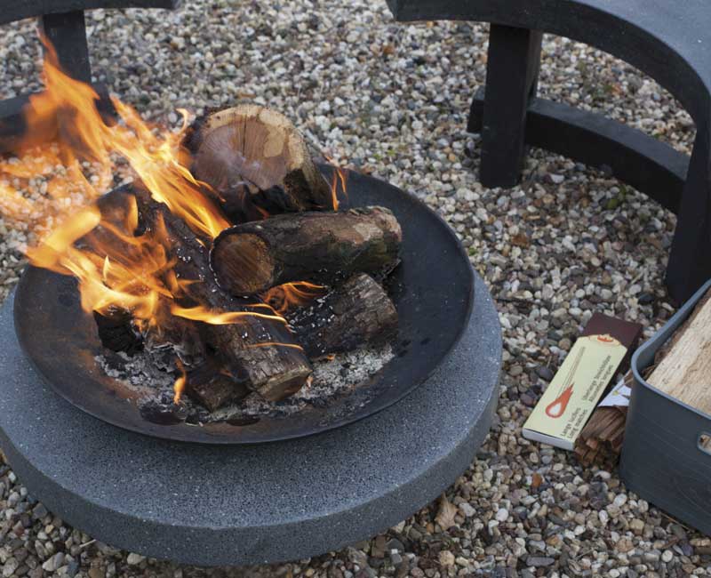 Feu de bois dans un brasero en fonte avec son support granit