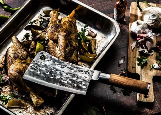 Couperet Olive Forged posé sur un plat de volaille