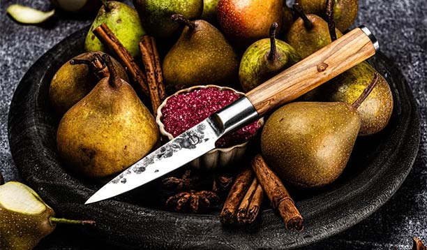 Couteau d’office Forged Olive dans un plat rempli de poire