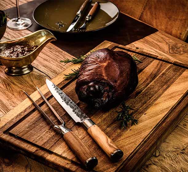 Fourchette à découper Forged Olive à côté d'un morceau de viande