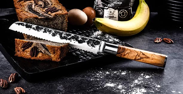 Couteau à pain Forged Olive posé près d'une brioche
