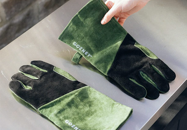 Gants résistants à la chaleur Gozney en daim posés sur une table