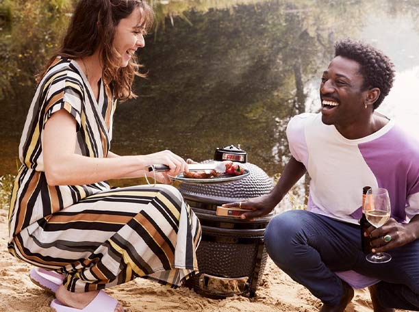 2 personnes discutant autour du barbecue kamado Original Compact Grill Guru