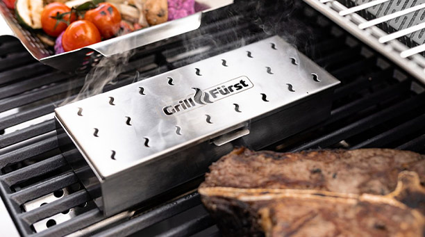 Boîte de fumage en inox Grillfürst posé sur une grille de barbecue gaz