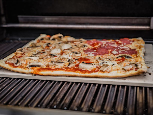 Cuisson d'une pizza sur la pierre à pizza rectangulaire en cordiérite Grillfürst